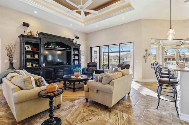 living room featuring ceiling fan, a towering ceiling, crown molding, and a tray ceiling