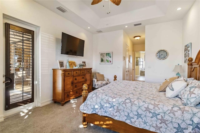 bedroom with ceiling fan, connected bathroom, and a tray ceiling