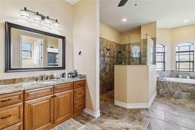 bathroom featuring ceiling fan, vanity, and independent shower and bath