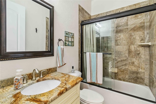 full bathroom with vanity, toilet, and enclosed tub / shower combo