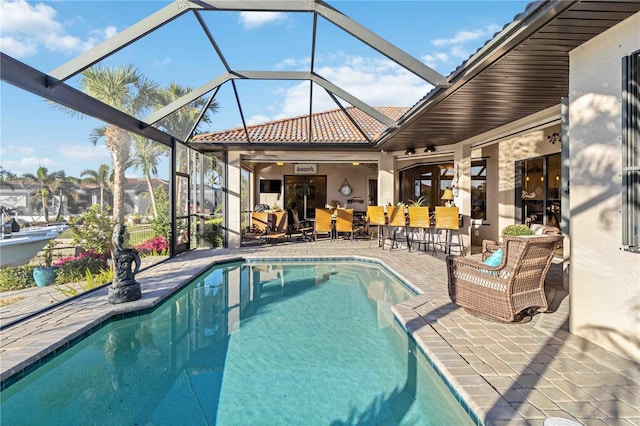 view of pool with glass enclosure, ceiling fan, and a patio area