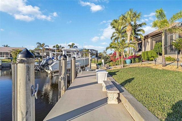 dock area featuring a lawn and a water view