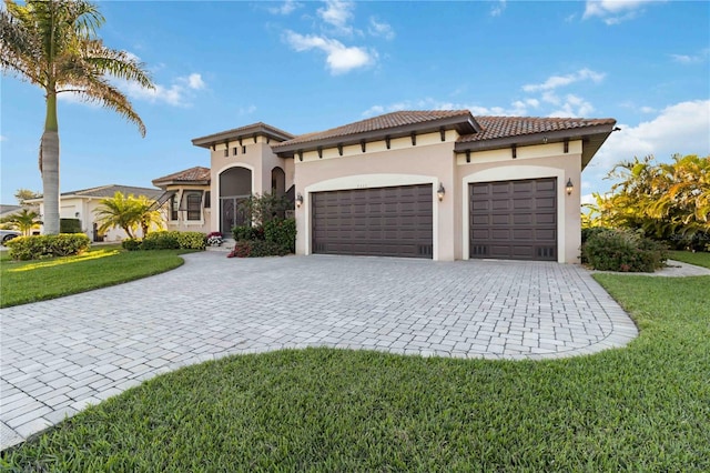 mediterranean / spanish house with a garage and a front lawn