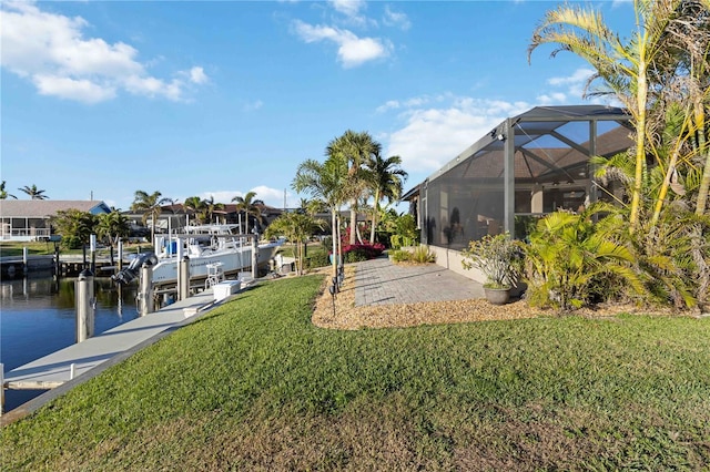 view of dock featuring a water view, glass enclosure, and a lawn