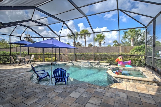 view of pool featuring an in ground hot tub, a patio, and glass enclosure