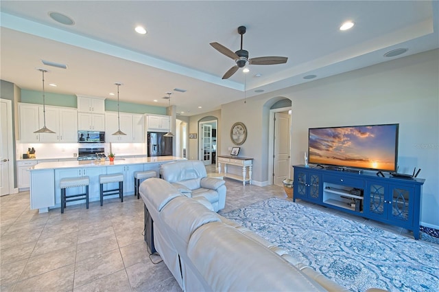 tiled living room with ceiling fan