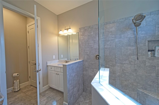 bathroom with tile patterned floors, vanity, and tiled shower