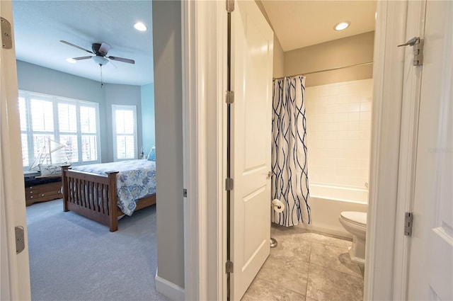 bedroom with connected bathroom, light colored carpet, and ceiling fan