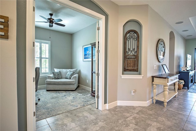 entrance foyer featuring ceiling fan, light tile patterned floors, and a textured ceiling