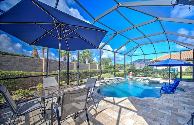 view of pool featuring an in ground hot tub, pool water feature, a patio area, and a lanai