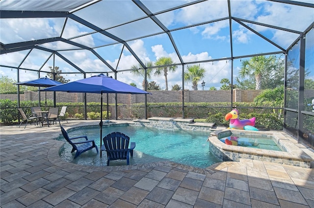 view of pool featuring glass enclosure, an in ground hot tub, a patio area, and pool water feature