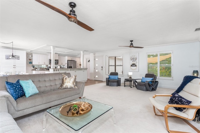 carpeted living room featuring ceiling fan and ornamental molding