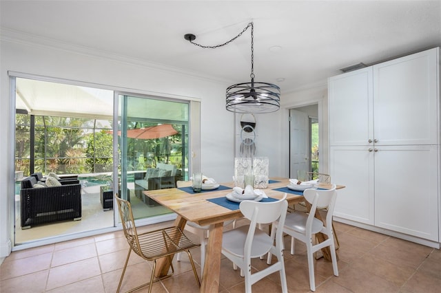 dining space featuring a notable chandelier, light tile patterned floors, and crown molding