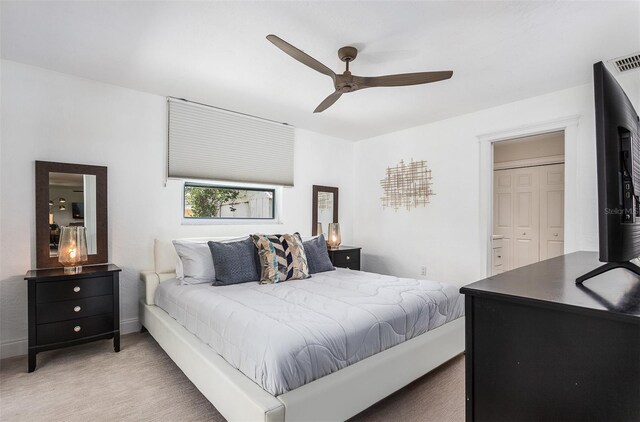 carpeted bedroom with ceiling fan and a closet