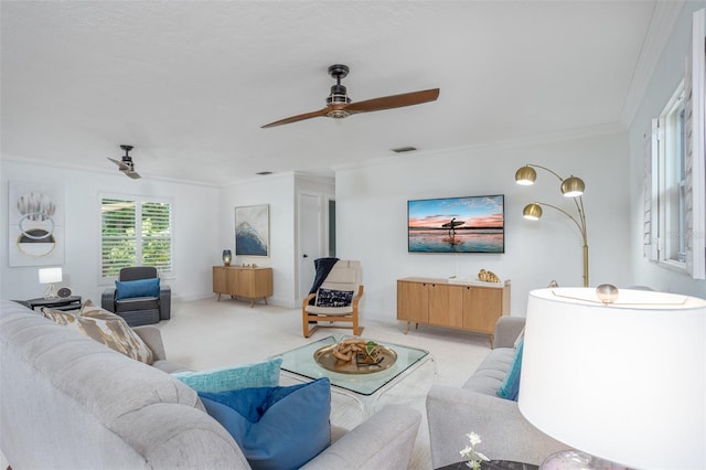 carpeted living room featuring ceiling fan and crown molding