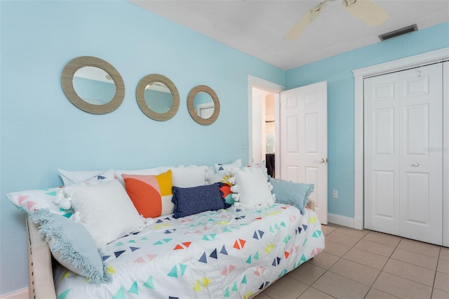 bedroom featuring ceiling fan, light tile patterned flooring, and a closet