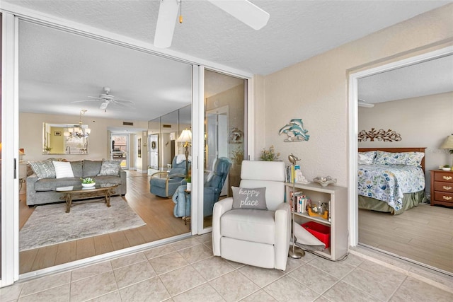 tiled living room with a textured ceiling and ceiling fan