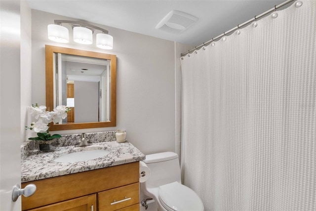 bathroom with toilet, curtained shower, and vanity