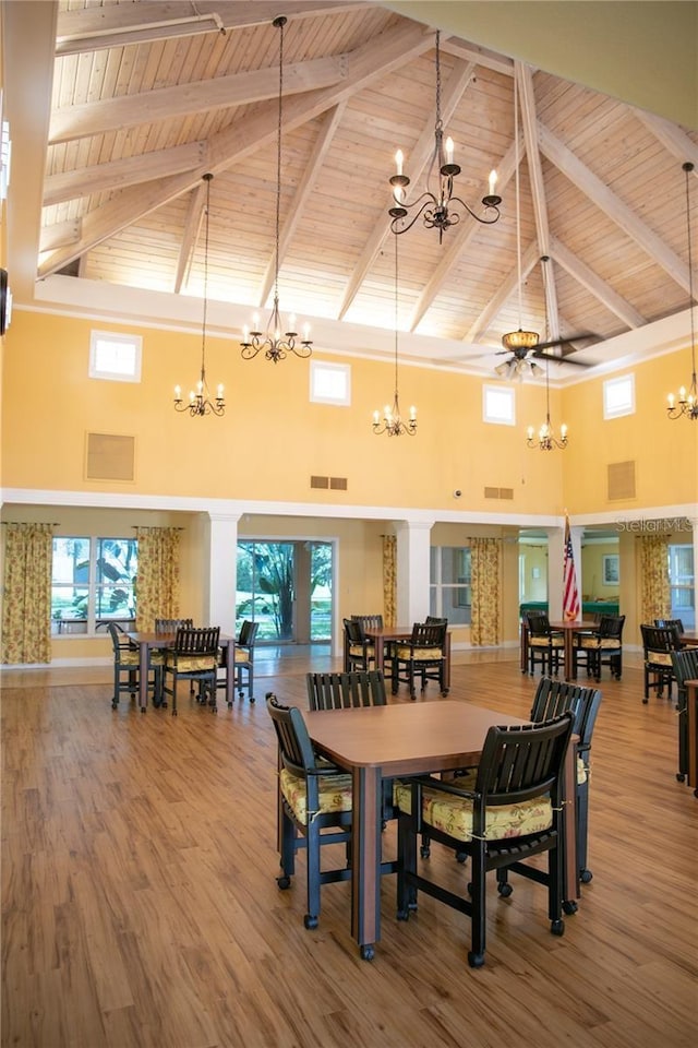 dining space featuring high vaulted ceiling, ceiling fan, and wood-type flooring