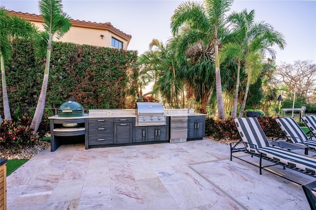 view of patio featuring exterior kitchen and a grill