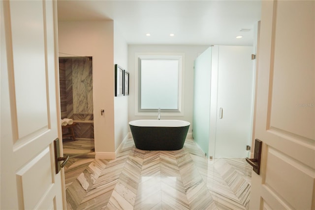 bathroom featuring plus walk in shower and parquet flooring