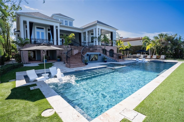 view of swimming pool featuring a yard, a patio, and an in ground hot tub