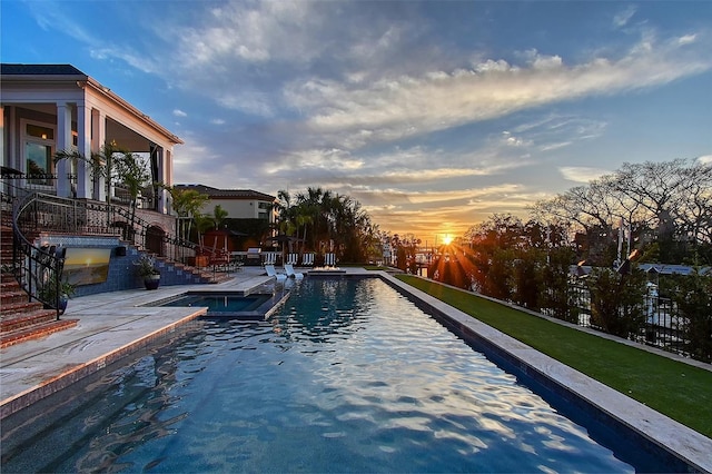 pool at dusk with a patio