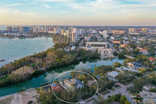 aerial view at dusk featuring a water view