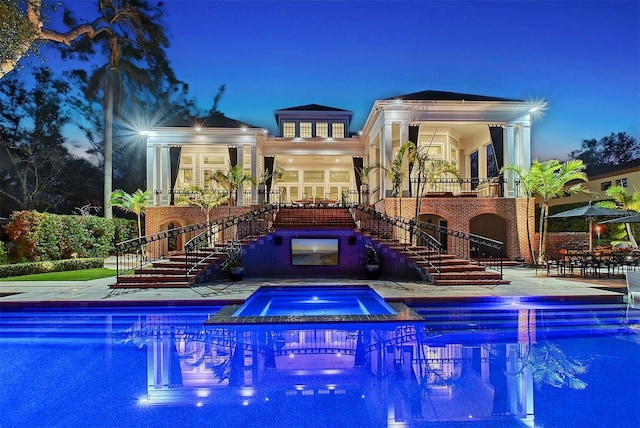 1541 Bay Point Dr, Sarasota, FL 34236 - pool at twilight with stairs, an in-ground hot tub, a patio, and an outdoor pool