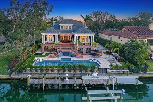1541 Bay Point Dr, Sarasota, FL 34236 - back of house with stairs, a fenced backyard, boat lift, a chimney, and an outdoor pool