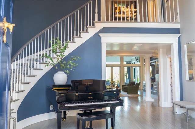 1541 Bay Point Dr, Sarasota, FL 34236 - entryway featuring ornate columns, stairs, a towering ceiling, wood finished floors, and baseboards