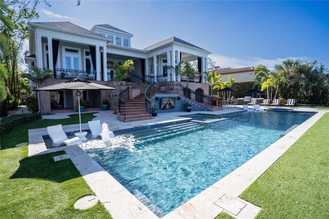 1541 Bay Point Dr, Sarasota, FL 34236 - rear view of property featuring a lawn, a patio, stairway, and a pool with connected hot tub