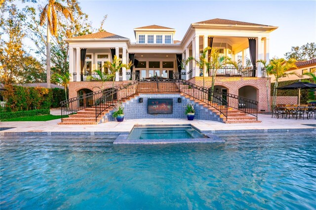 1541 Bay Point Dr, Sarasota, FL 34236 - rear view of property featuring stairway, an outdoor pool, an in-ground hot tub, a patio area, and a balcony