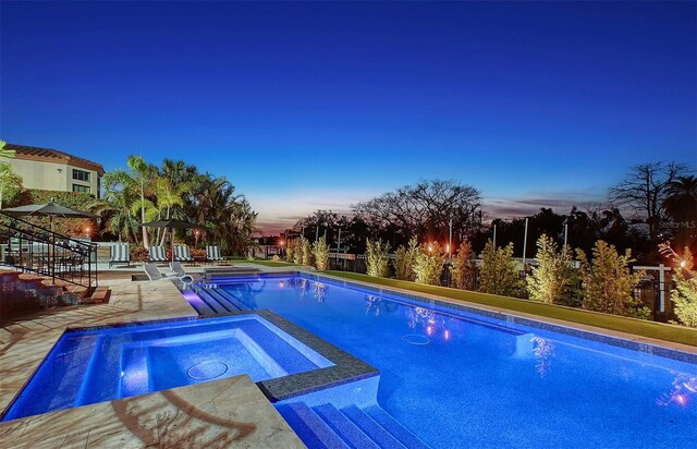 1541 Bay Point Dr, Sarasota, FL 34236 - pool at dusk featuring a pool with connected hot tub and a patio