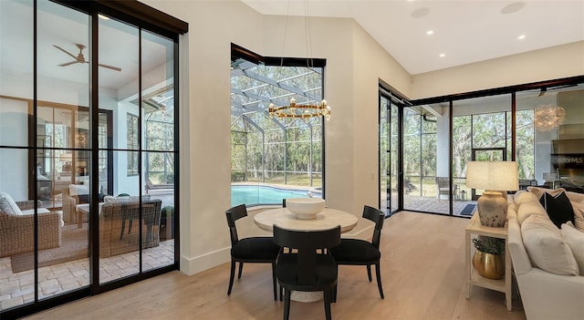 dining area featuring ceiling fan with notable chandelier and light wood-type flooring