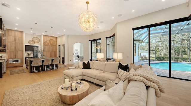 living room featuring a chandelier, a wealth of natural light, and light hardwood / wood-style floors