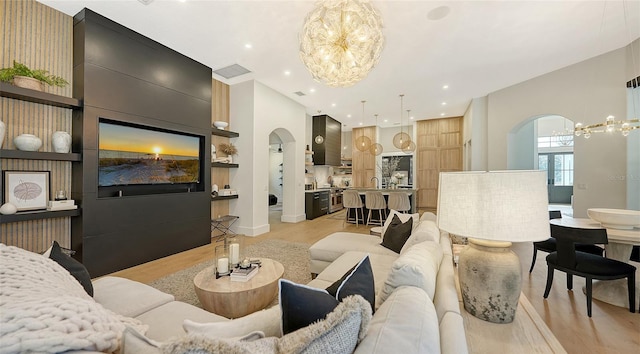 living room with sink, light hardwood / wood-style floors, and a chandelier