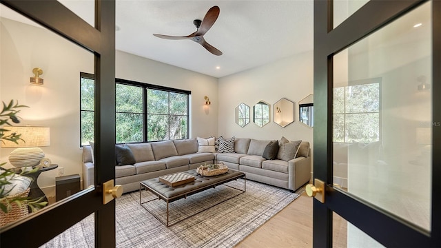 living room featuring light hardwood / wood-style flooring and ceiling fan