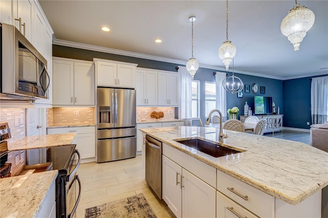 kitchen with stainless steel appliances, a center island with sink, tasteful backsplash, and sink