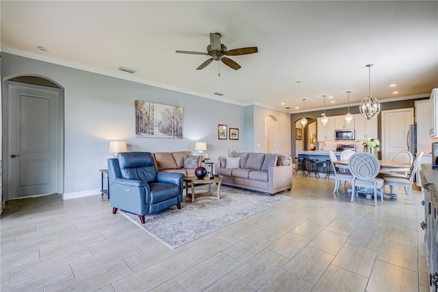 living room featuring ceiling fan and ornamental molding