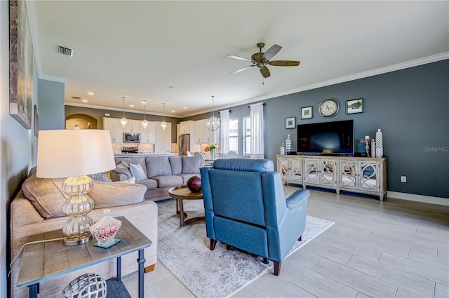 living room with ceiling fan and crown molding