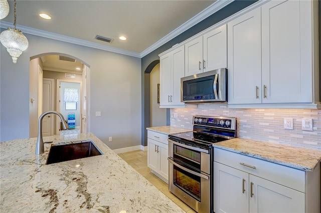 kitchen featuring sink, white cabinetry, hanging light fixtures, light stone countertops, and stainless steel appliances