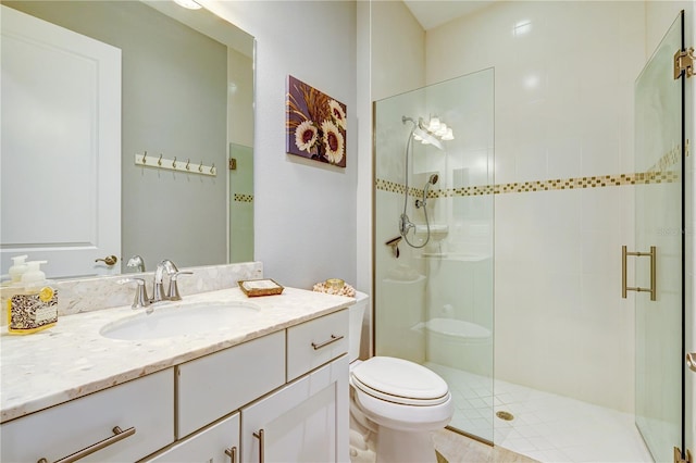 bathroom featuring a shower with shower door, toilet, and vanity