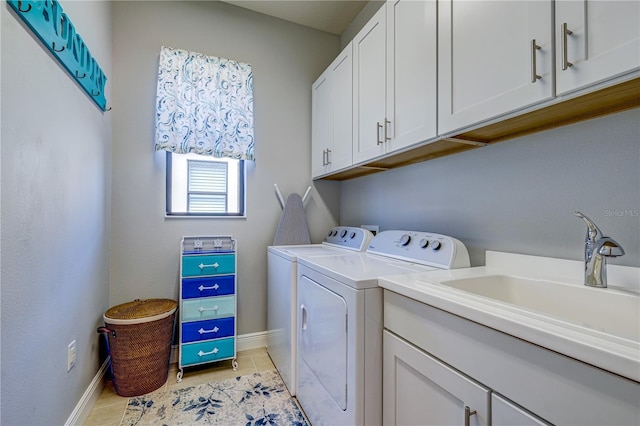 laundry area featuring cabinets, separate washer and dryer, and sink