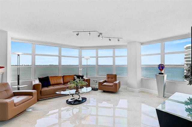 sunroom featuring a water view