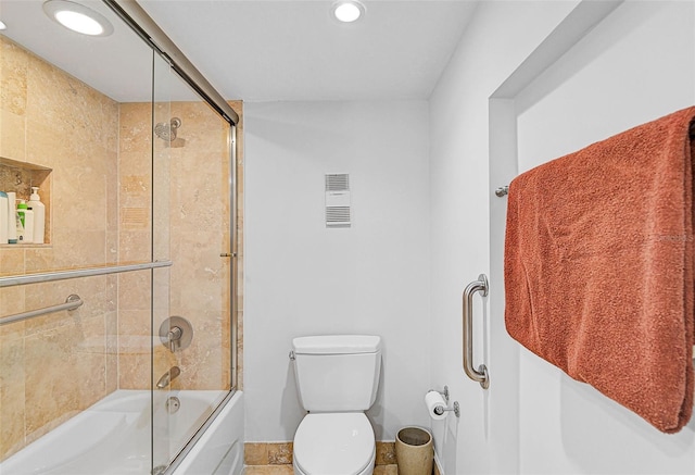 bathroom with tile patterned flooring, enclosed tub / shower combo, and toilet