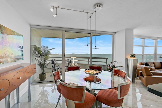 dining room with floor to ceiling windows and a water view