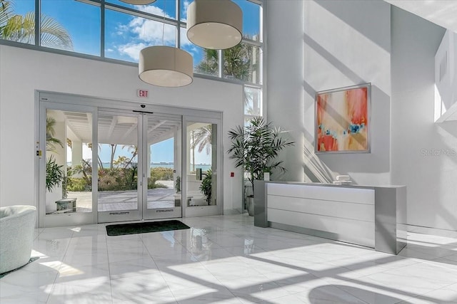 interior space with a high ceiling, french doors, and plenty of natural light