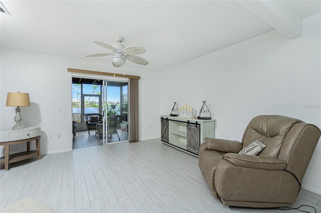 living area featuring beam ceiling, ceiling fan, and light hardwood / wood-style flooring