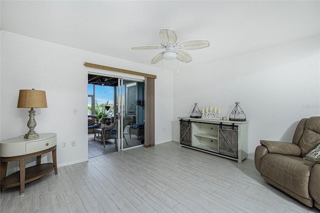 living room with ceiling fan and light wood-type flooring